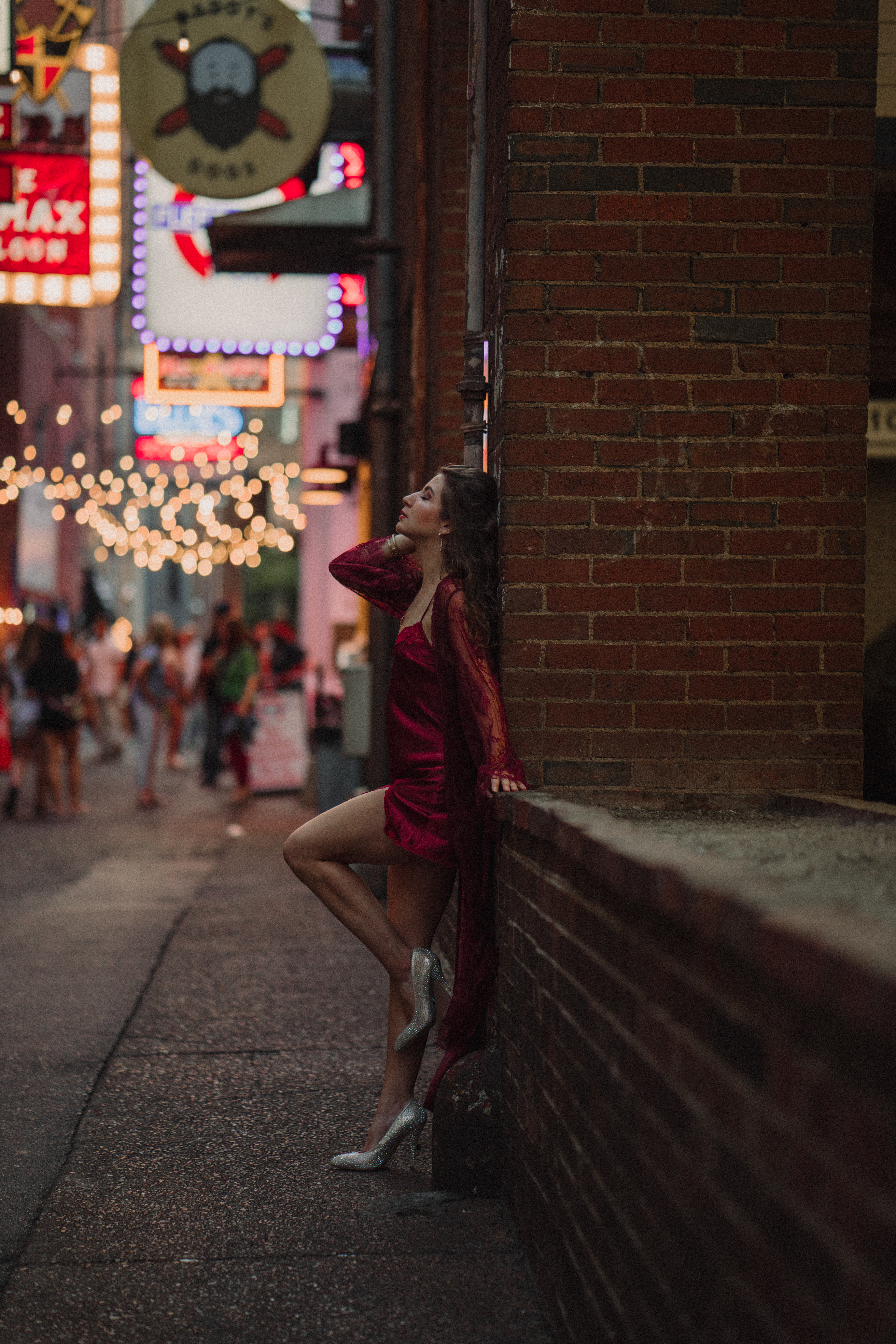 Nashville Tennessee Jazz Musician poses in Printer's Alley at night for album cover. She leans back against a brick wall with her shoe propped up.