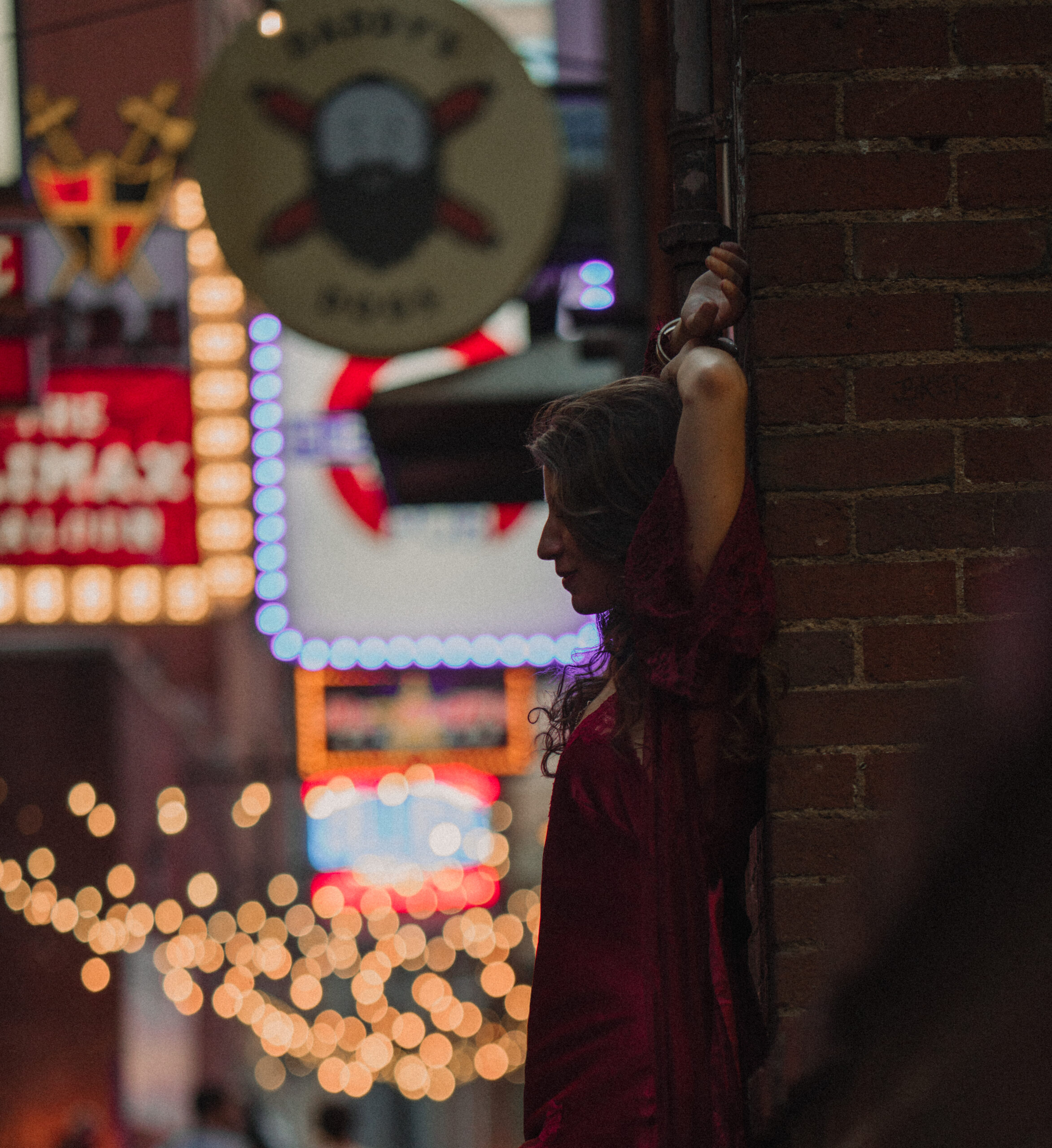 Nashville Tennessee Jazz Musician poses in Printer's Alley at night for album cover. She leans back against a brick wall with her shoe propped up.