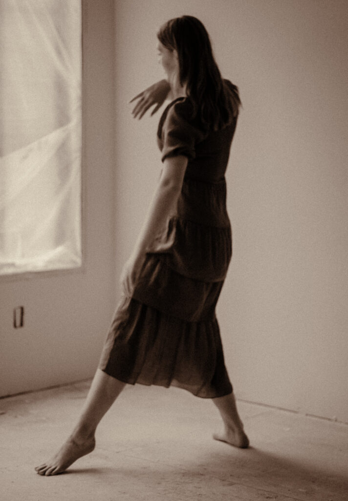 Ballerina Dances in her unfinished home in a blue dress.